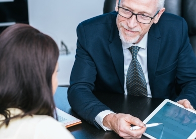 Male advisor showing female client information on a tablet